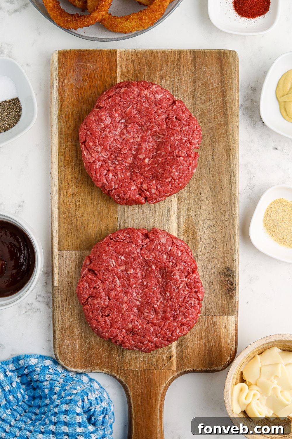 Chuck Wagon Burger 9 Raw hamburger patties expertly formed and ready for cooking on a wooden cutting board.