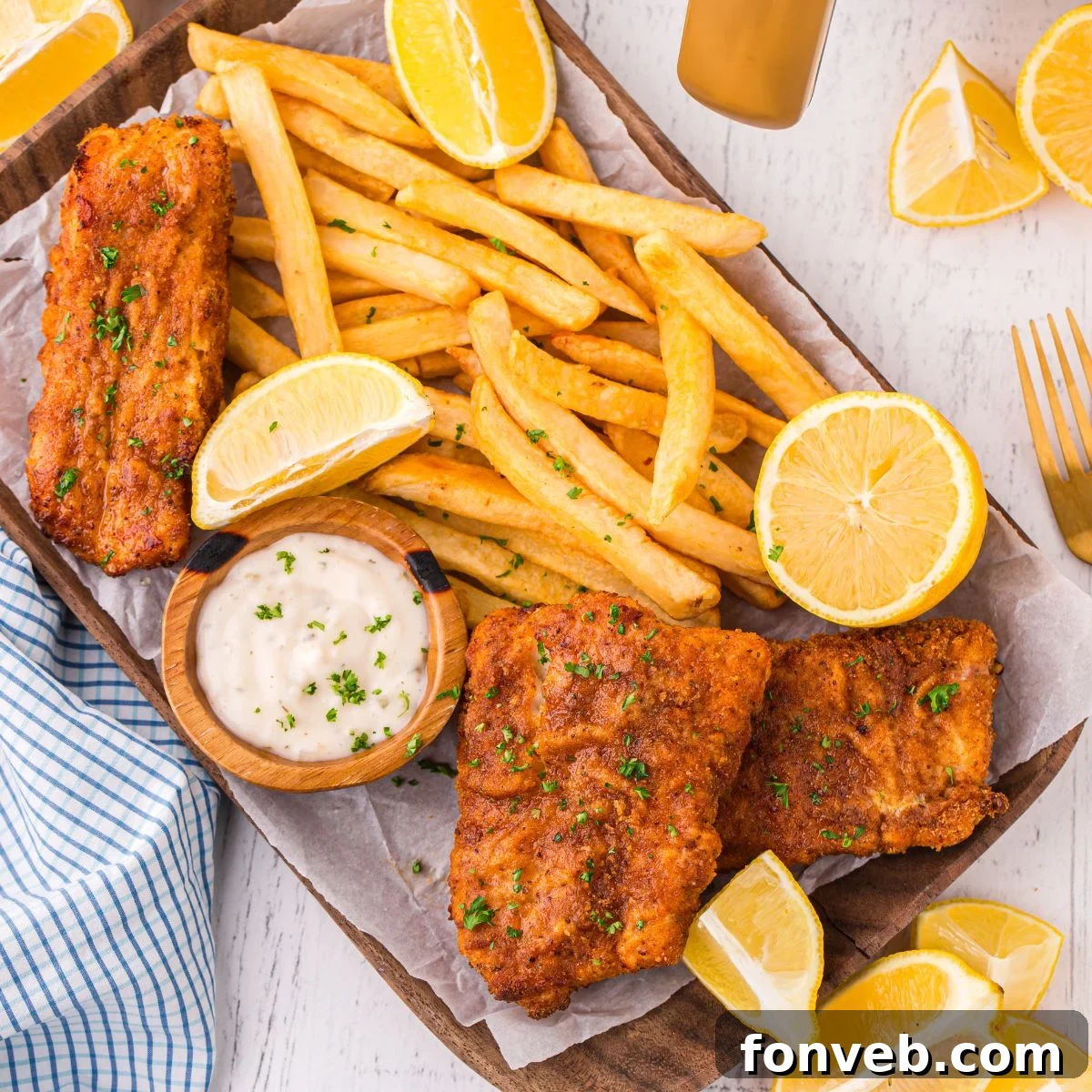Crispy Air-Fried Fish and Chips 4 Air Fryer Fish And Chips on a platter with fries and lemon wedges and tartar sauce on side
