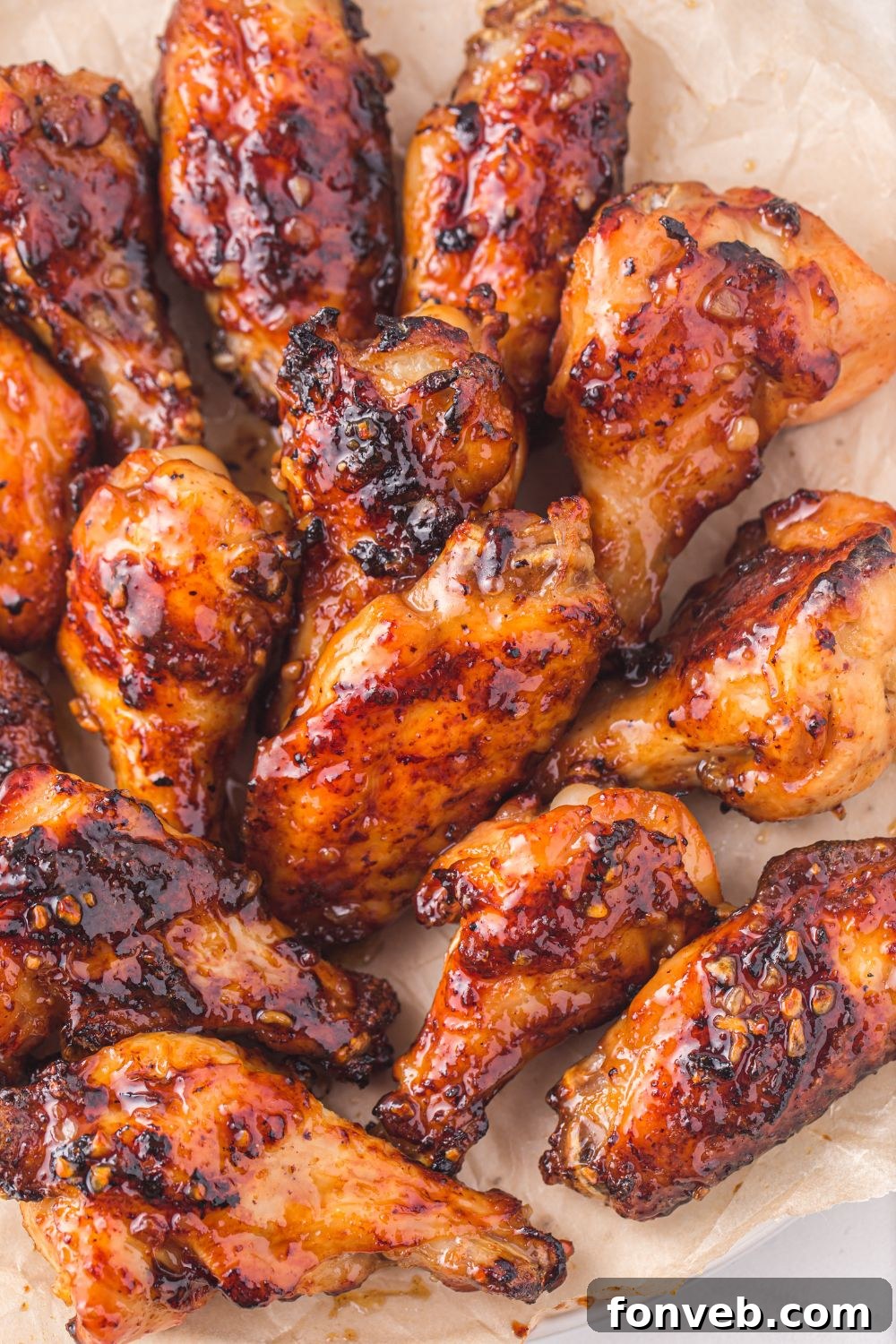 Air Fryer Honey Chicken Wings spread out on a tray showing the sticky glaze./