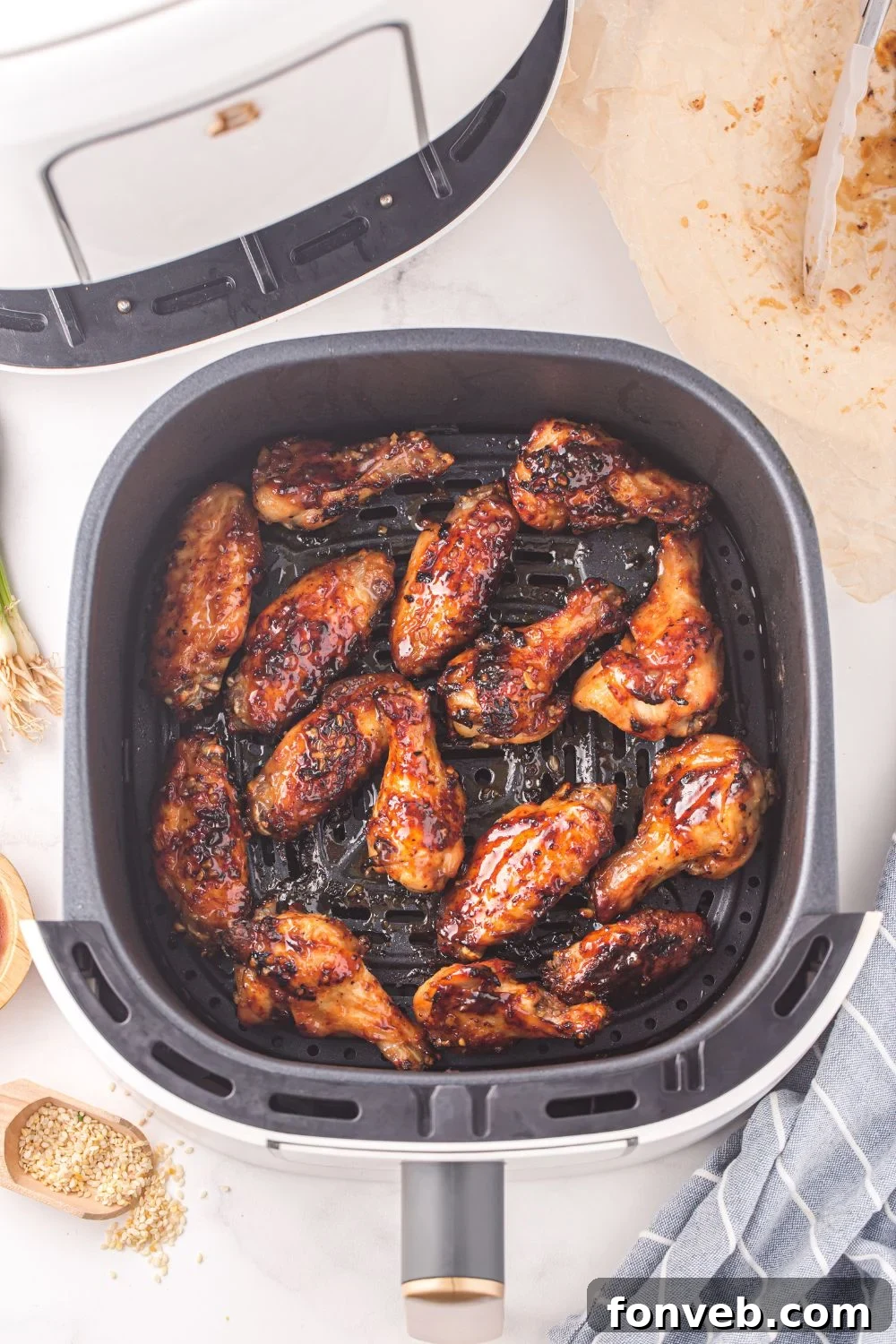 air fryer with glazed chicken wings in air fryer