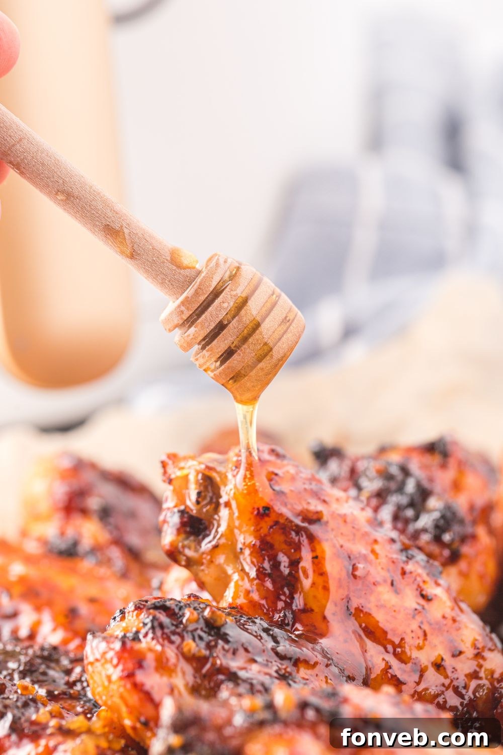 Honey Chicken Wings on plate with honey being drizzled on top 