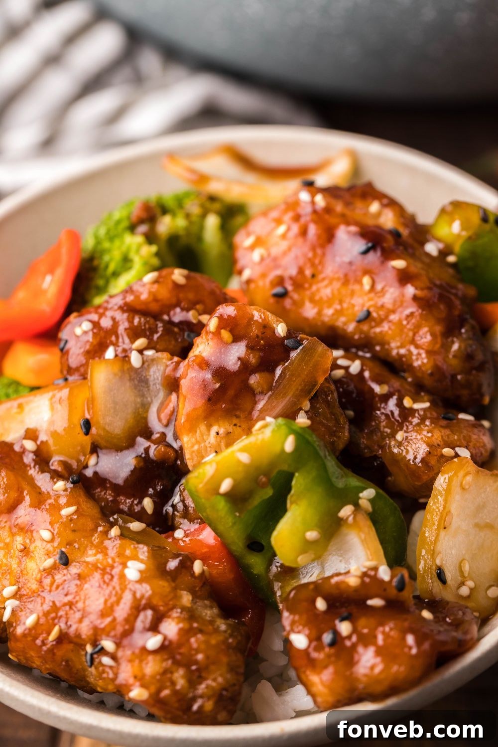 A bowl of General Tso Chicken with a kitchen towel placed neatly on the side, ready to be served.