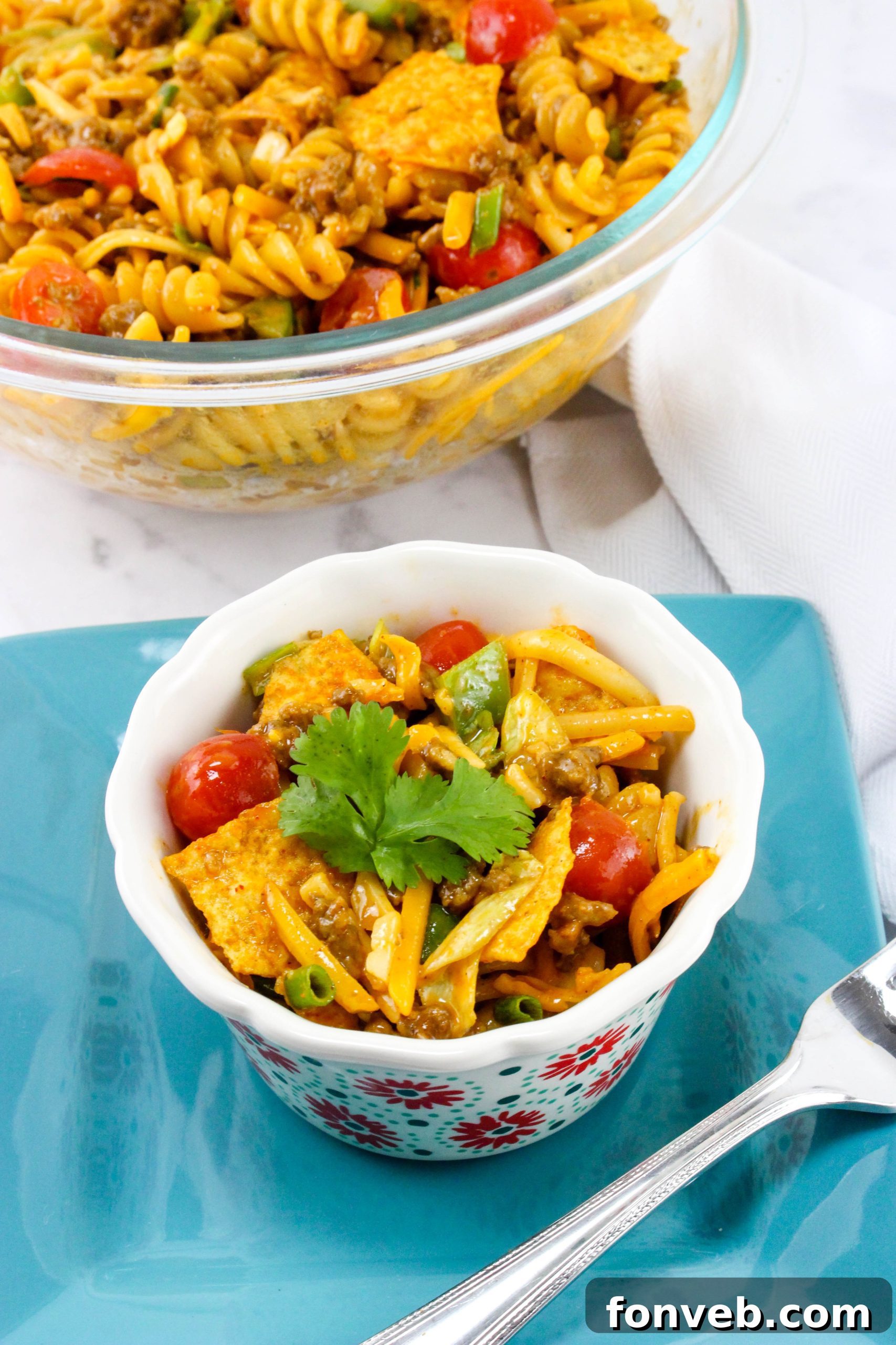 A large serving bowl filled with the colorful Doritos Taco Pasta Salad.