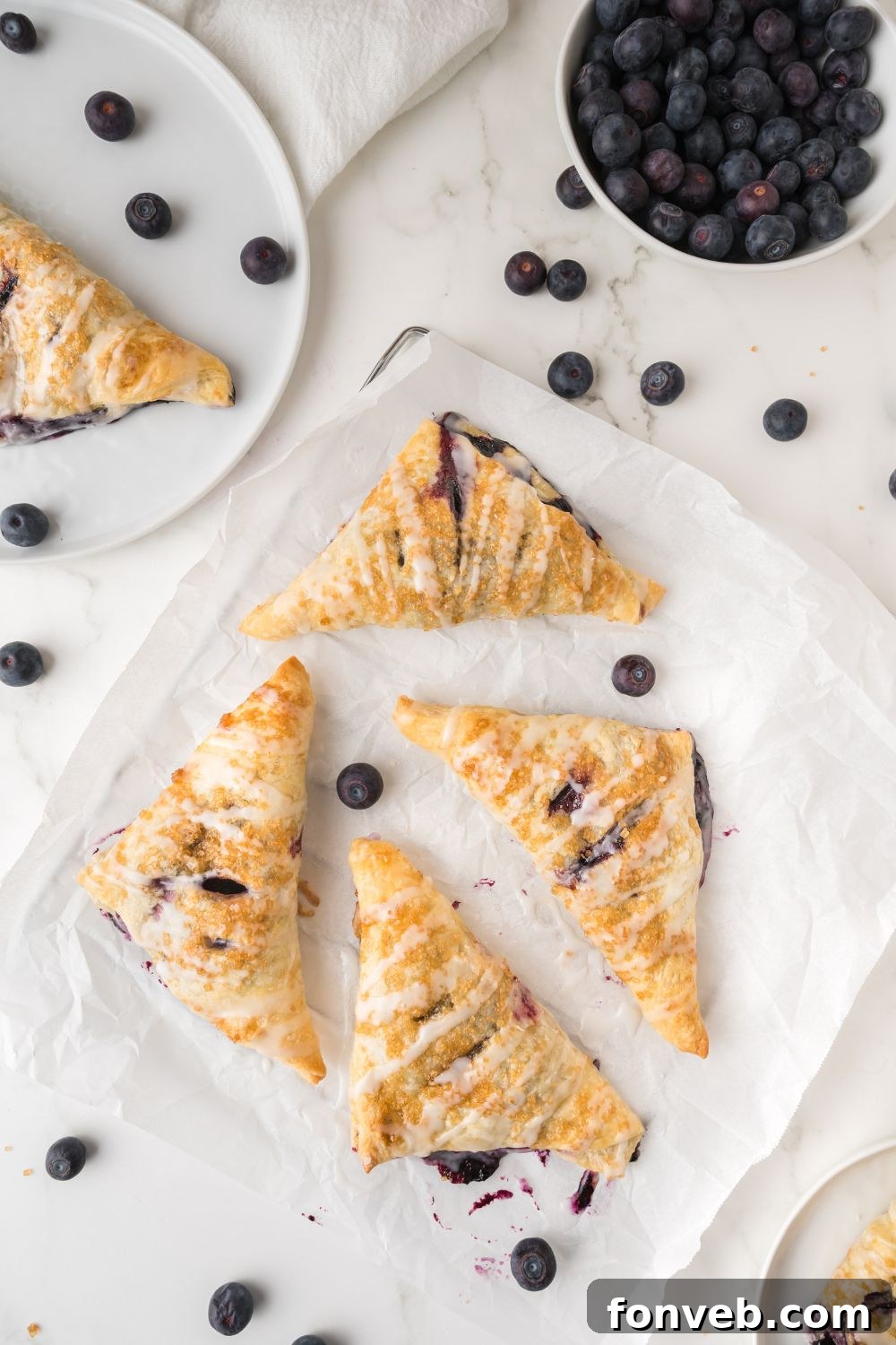 A delicious spread of golden blueberry turnovers laid out on a table, ready to be enjoyed.