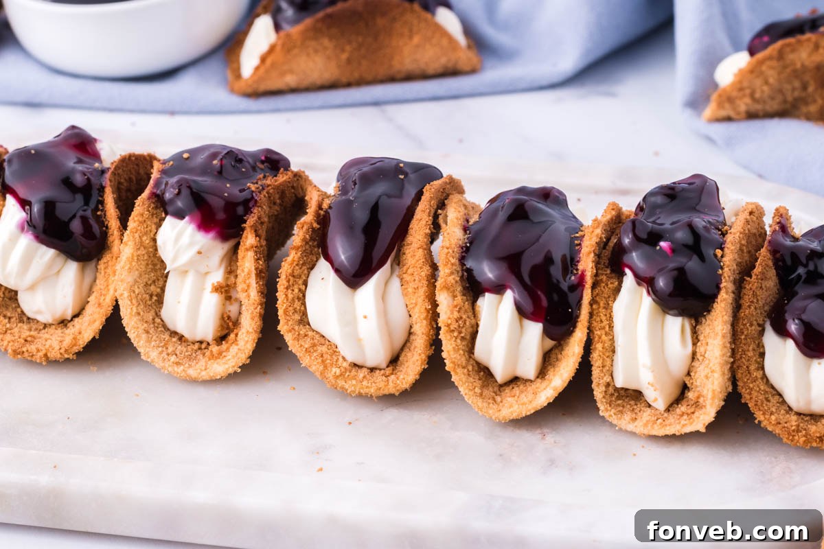 Blueberry Cheesecake Taco Twist 10 Photo of blueberry cheesecake tacos lined up on a marble serving platter.