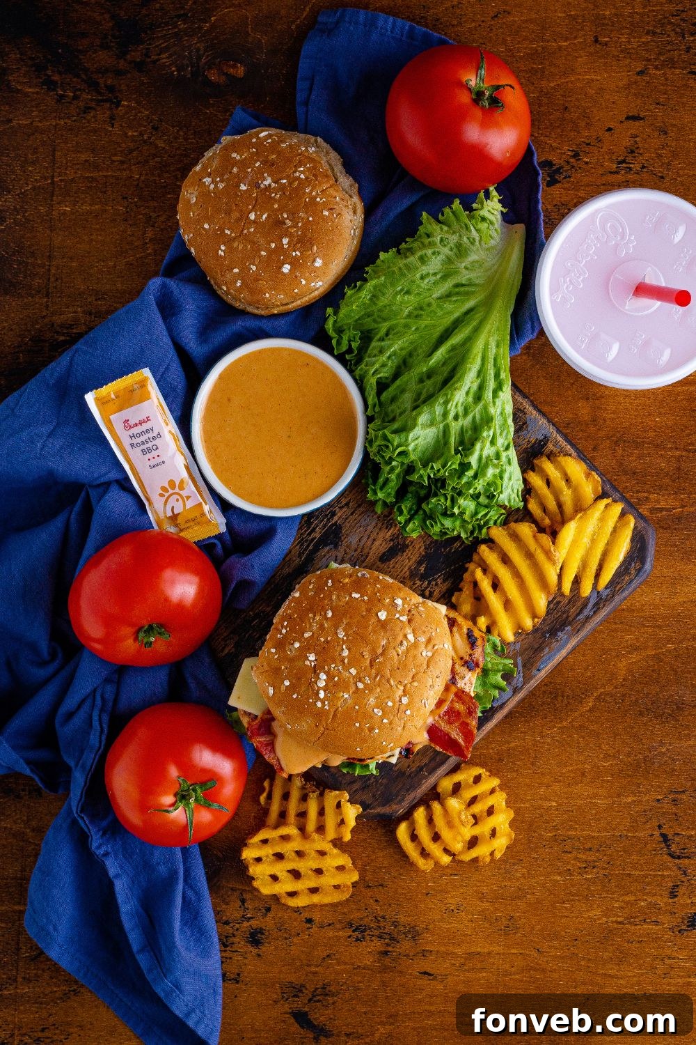 An inviting overhead view of a table laden with Chick-fil-A style grilled chicken sandwiches, drinks, and crispy french fries, creating a perfect meal spread.