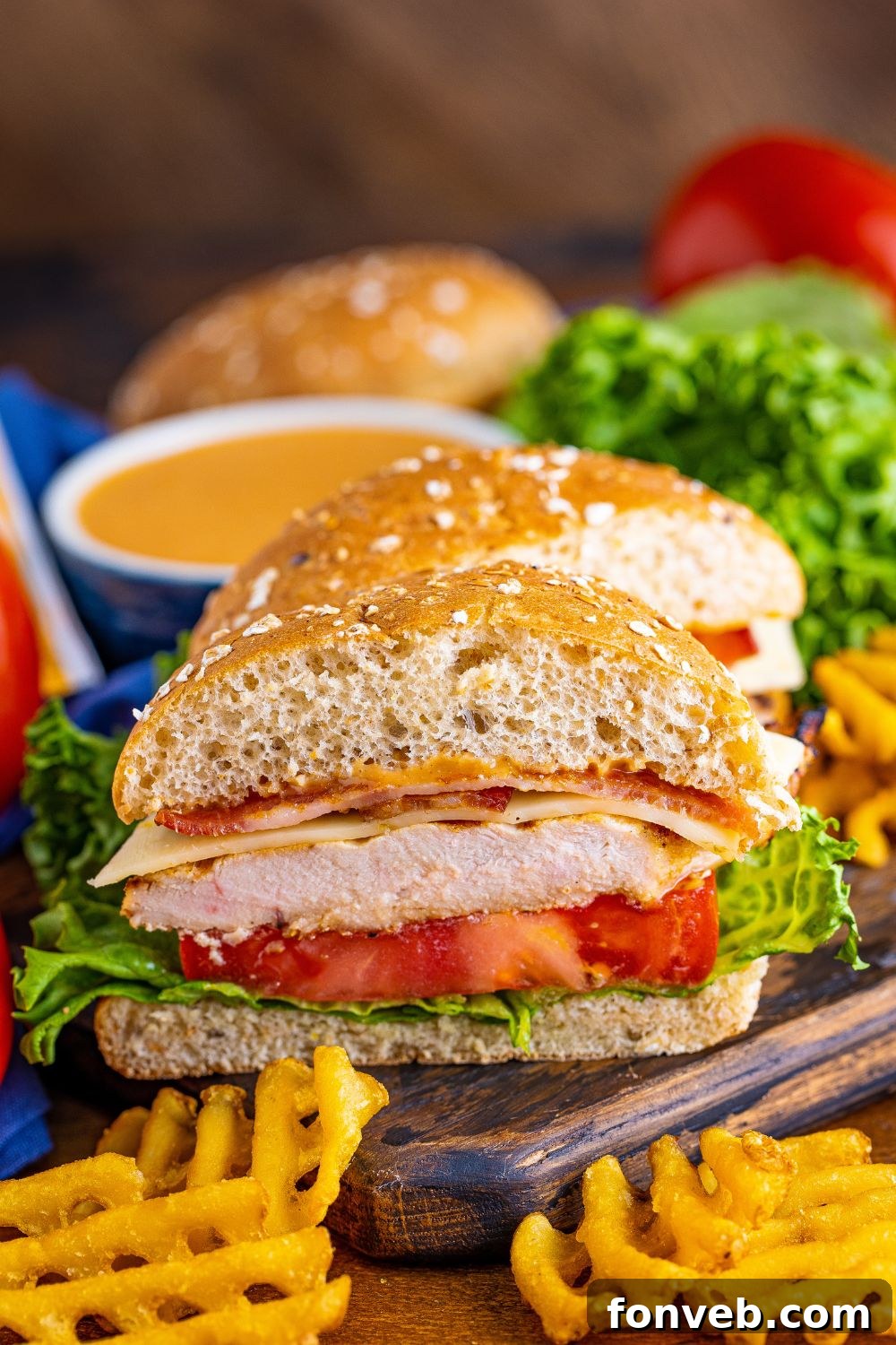 A Chick-fil-A style grilled chicken sandwich, perfectly sliced in half on a cutting board, revealing all its delicious layers.