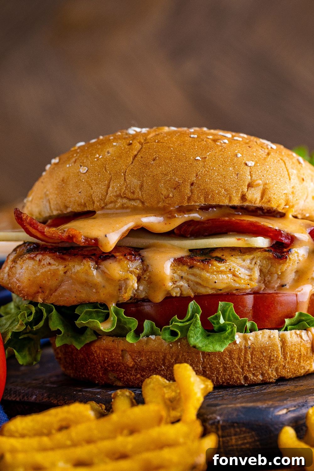 A tempting side view of a Chick-fil-A style grilled chicken sandwich, showcasing the height and layers of deliciousness.