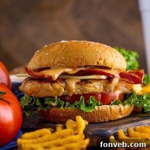 Chick-fil-A Grilled Chicken Sandwich on table with tomatoes to the side and waffle fries in front of the sandwich