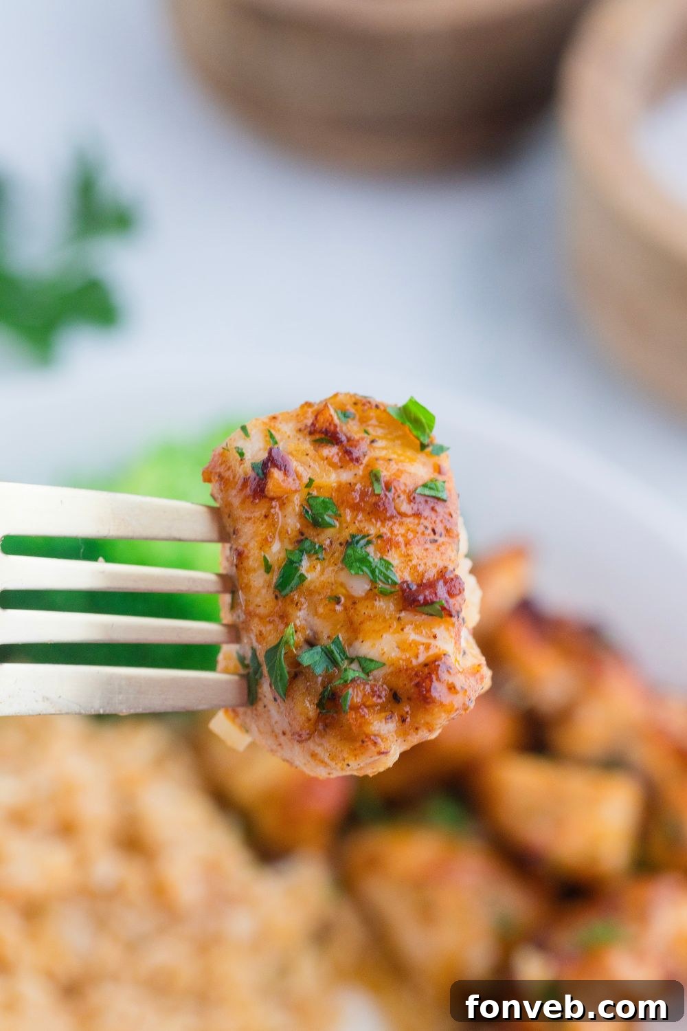 Garlic Butter Chicken Bite on fork above plate