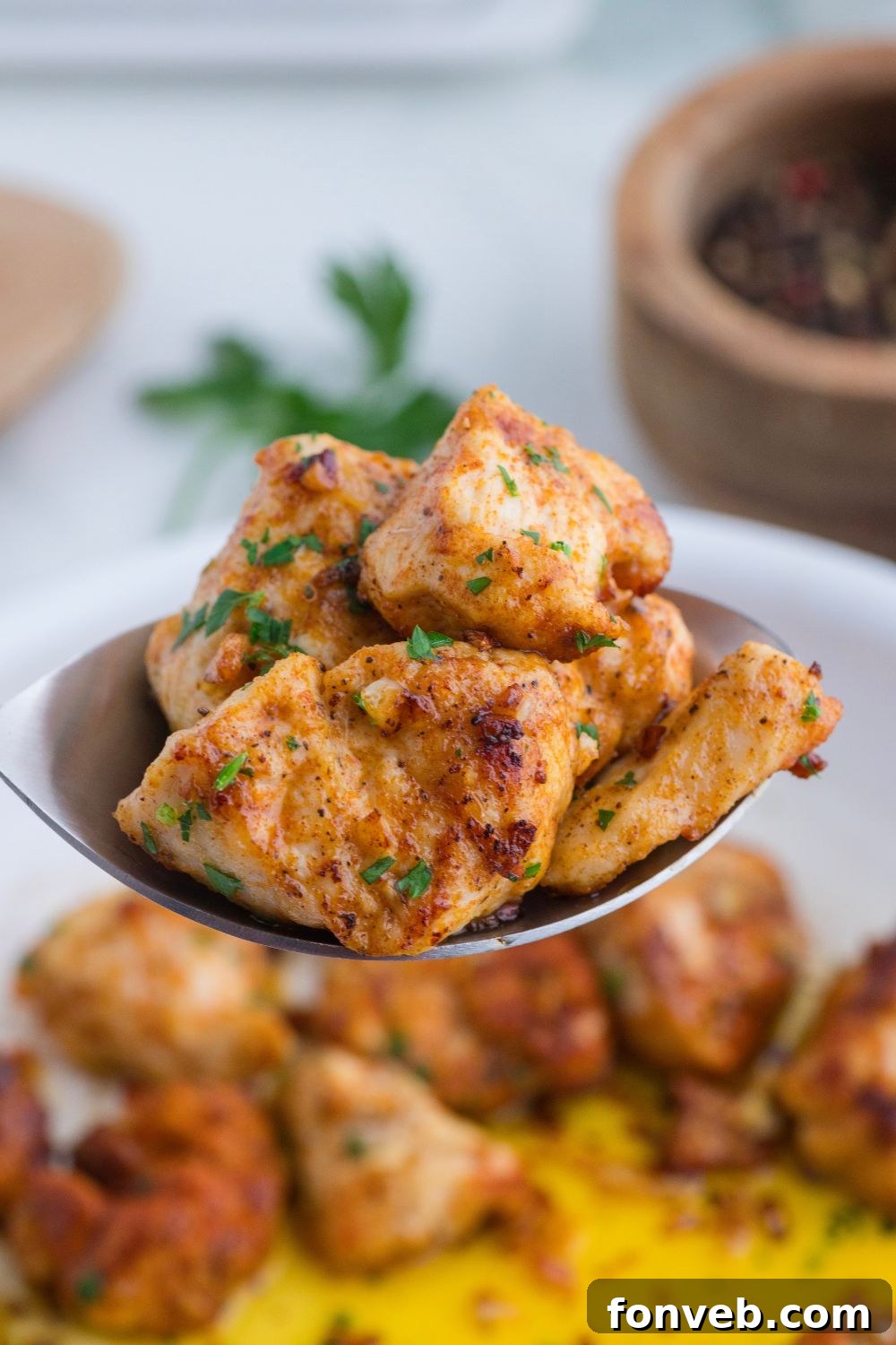 spoon of diced chicken above the skillet