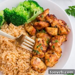 Garlic Butter Chicken Bites on plate with rice and broccoli on side of it