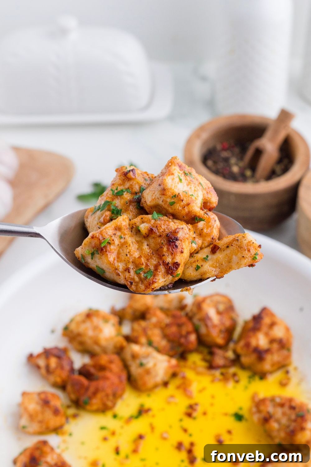 spoon with pieces of garlic butter chicken bites on it