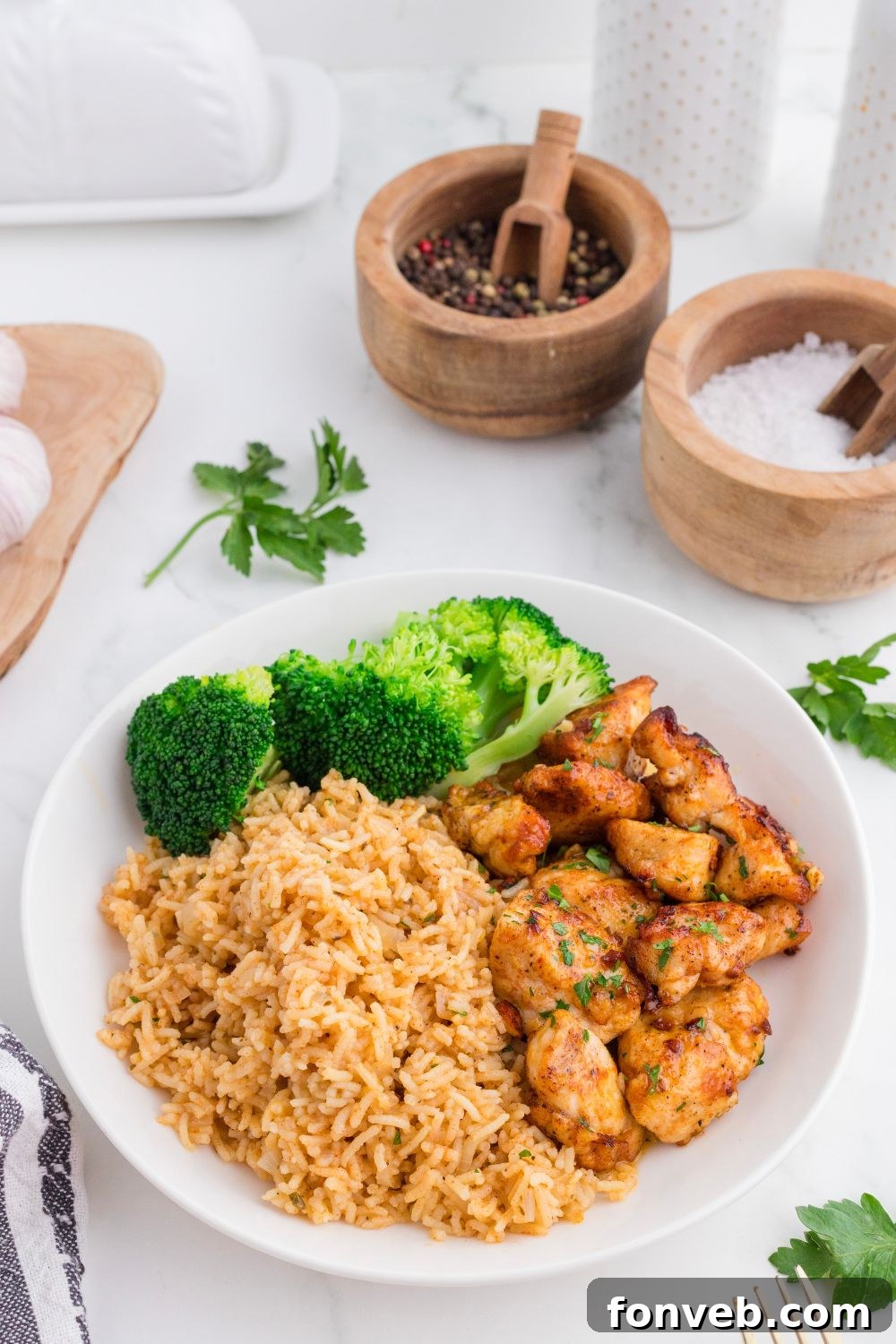 plate on table with Garlic Butter Chicken Bites, rice and broccoli on it