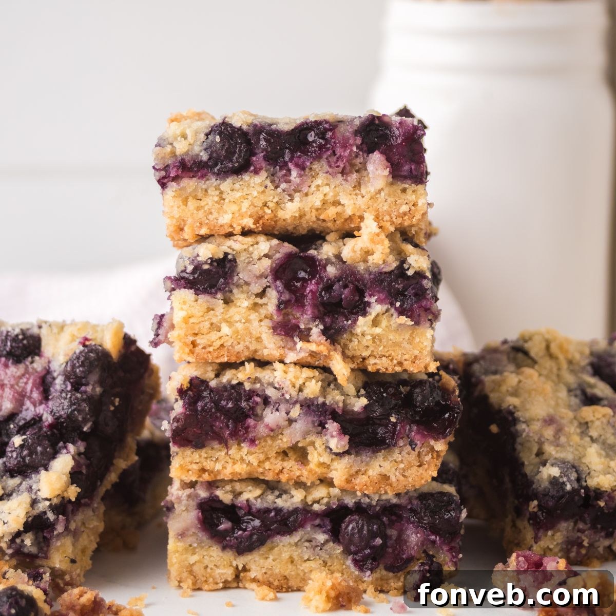 Blueberry Crumb Bars on table and a few stacked on top of each other 