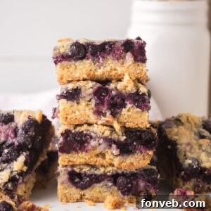 Blueberry Crumb Bars on table and a few stacked on top of each other