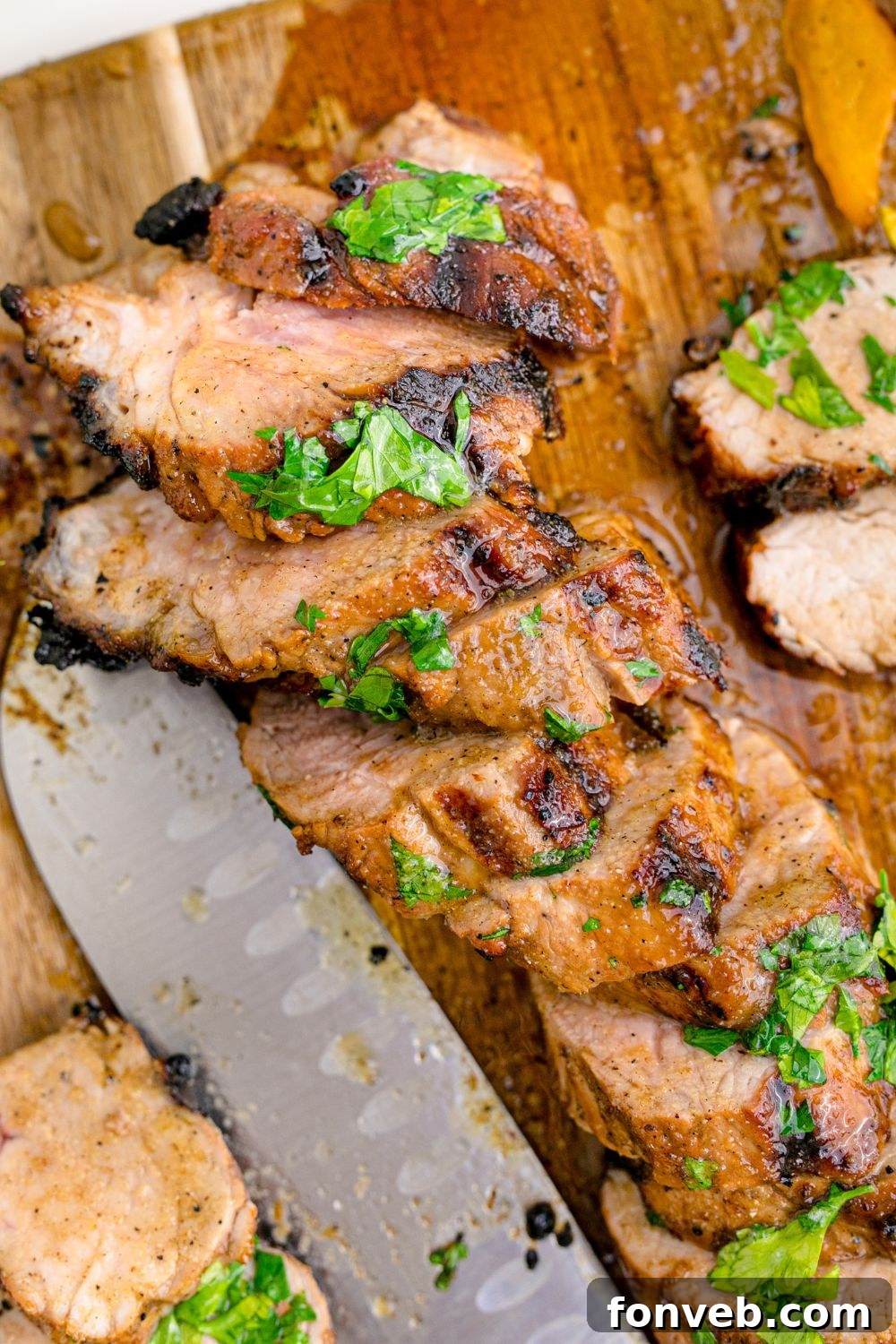 Grilled Pork Tenderloin sliced and then a knife set to the side 