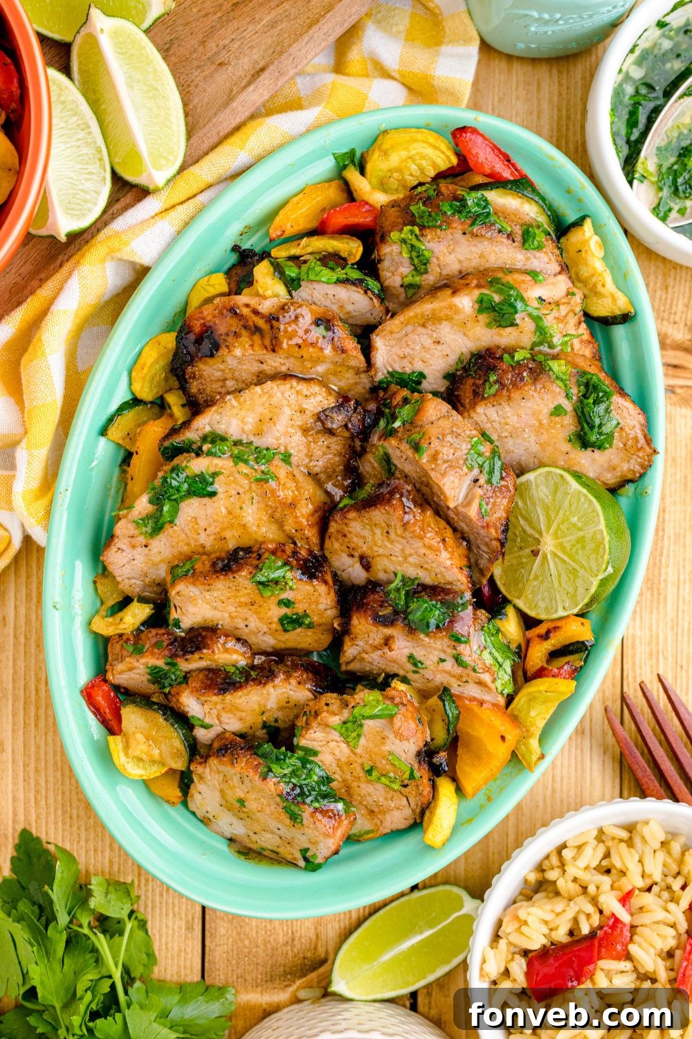 Grilled Pork Tenderloin on a tray with limes and rice beside the tray 