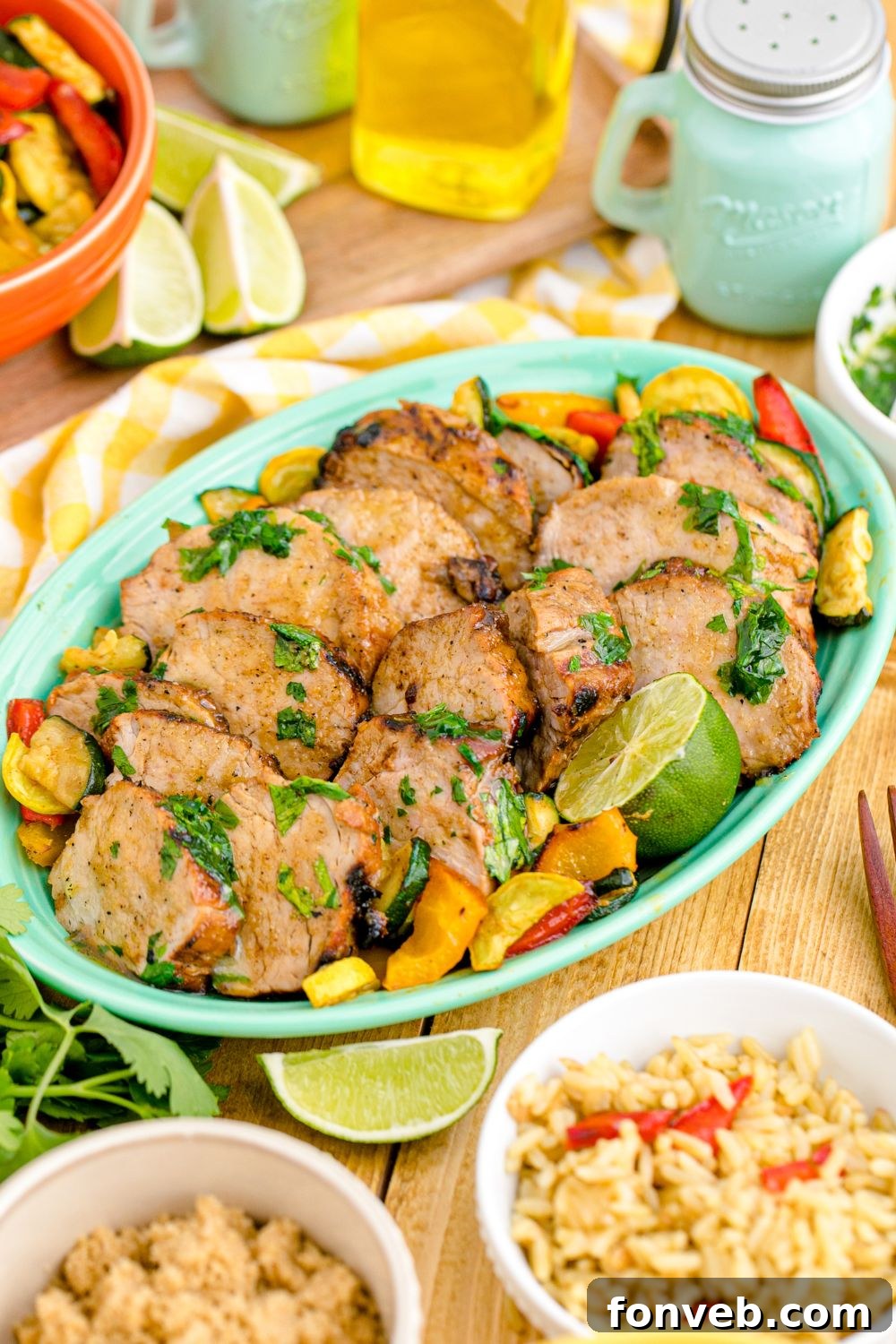 Grilled Pork Tenderloin in a serving tray with rice and other ingredients around it on the table