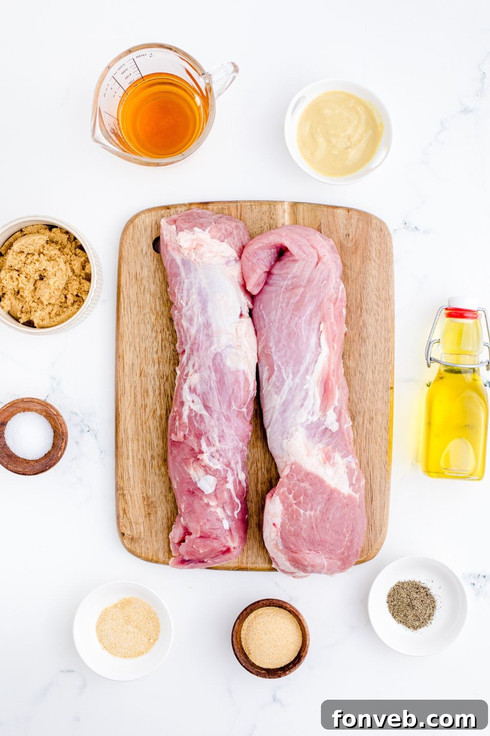 ingredients for grilled pork tenderloin on a cutting board and bowls of ingredients around the cutting board