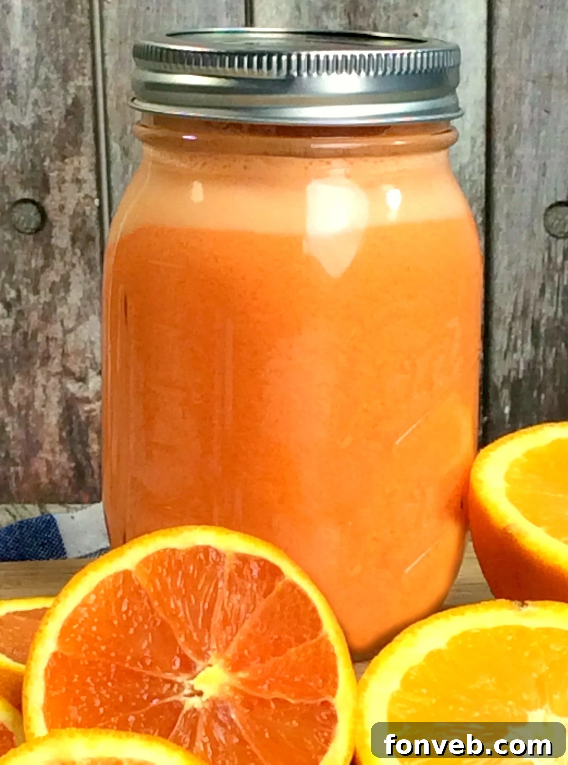 Homemade Orange Creamsicle Moonshine in mason jars, garnished with orange slices and mint.