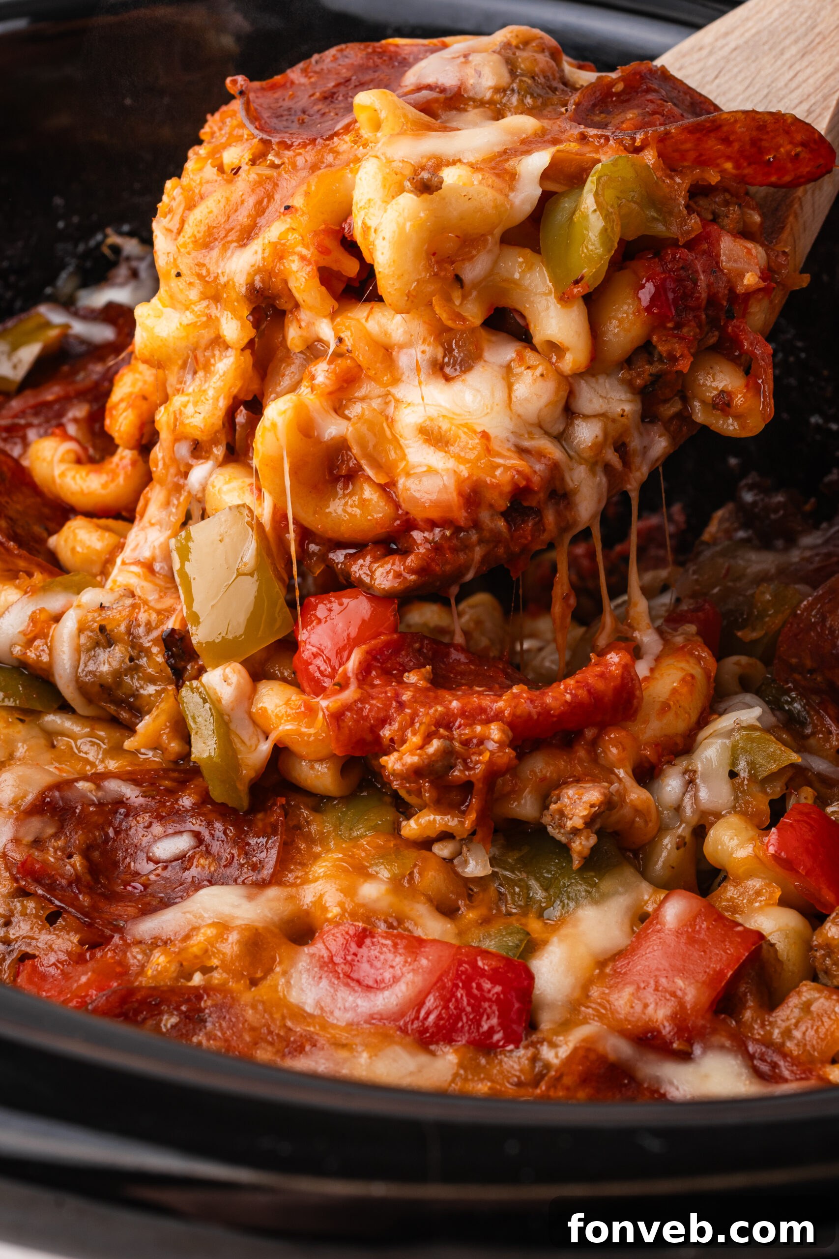 Slow Cooker Pizza Casserole up close being lifted by a spoon