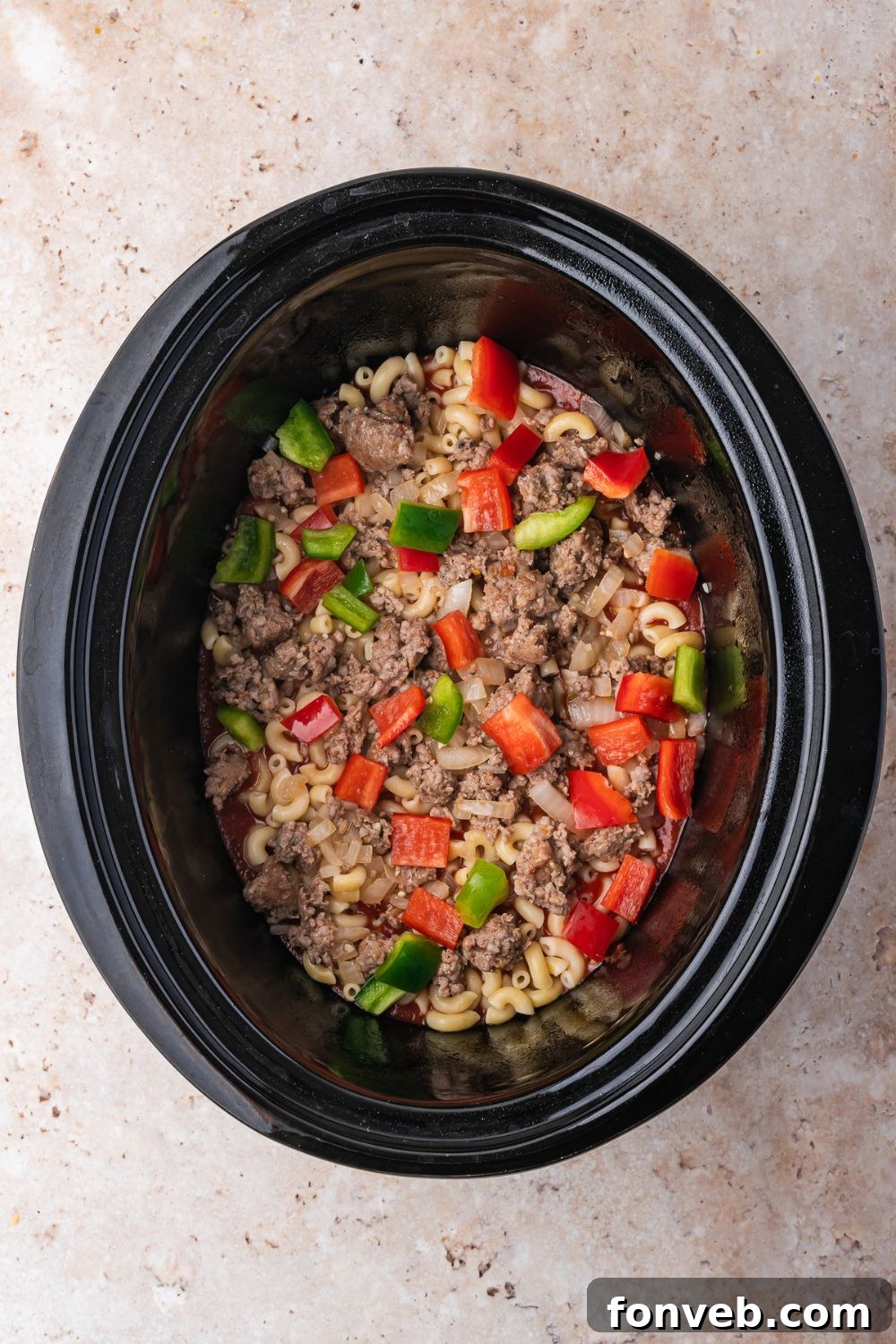 overhead look of Slow Cooker Pizza Casserole being assembled