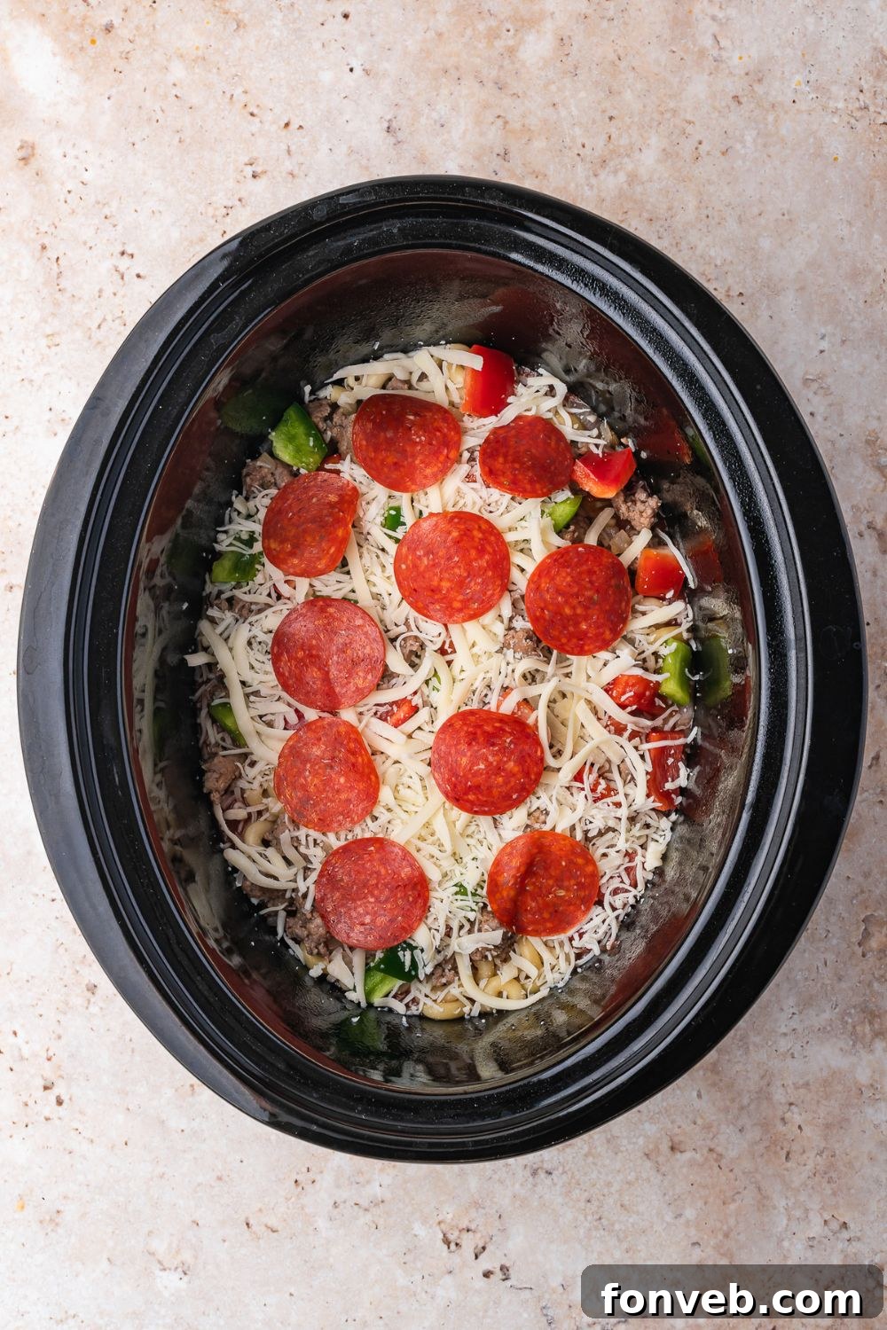 overhead of assembling Slow Cooker Pizza Casserole on table