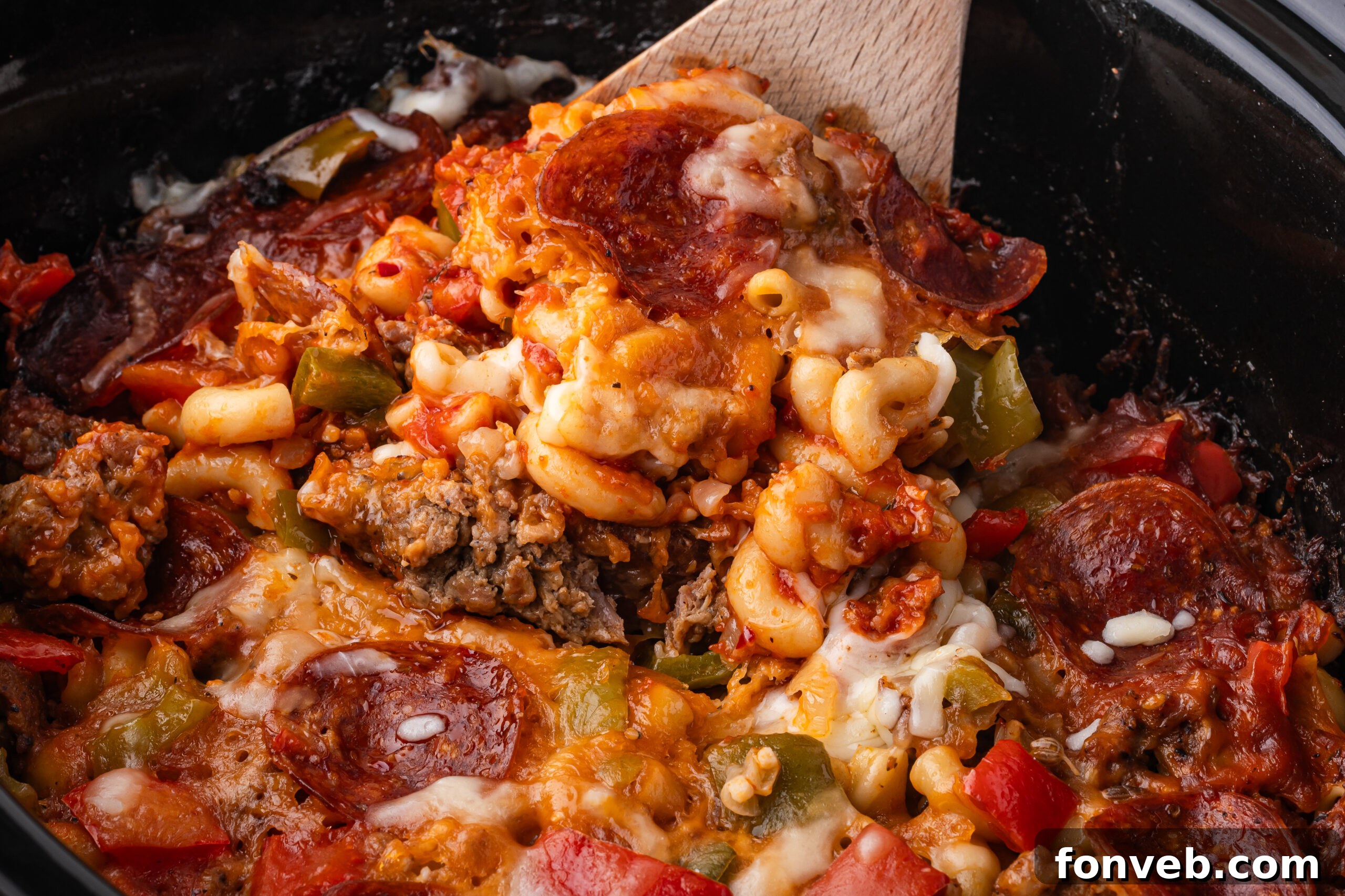 spoon lifting up some of the Slow Cooker Pizza Casserole out of the crock pot