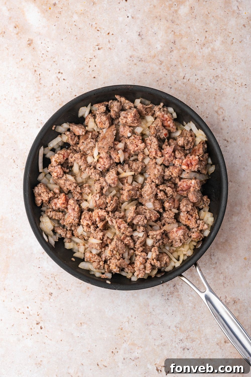 skillet with cooked hamburger and onions in skillet