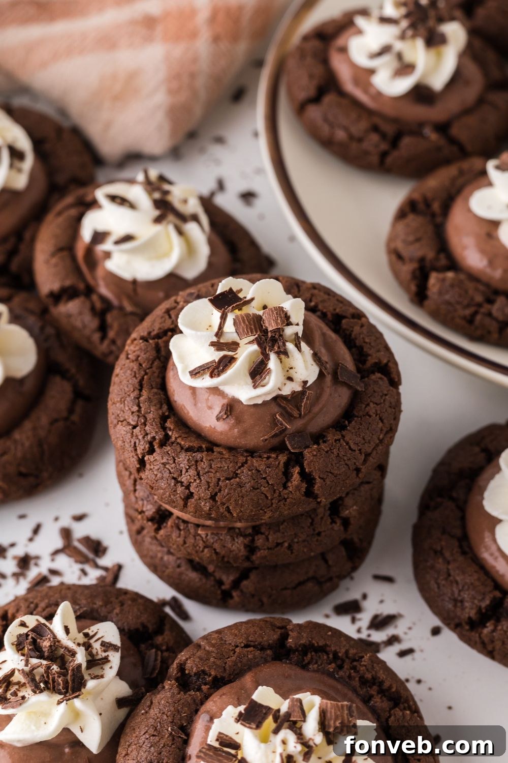 Chocolate Pie Cookies elegantly stacked on a wooden table, surrounded by other delightful cookies, creating a tempting dessert spread.