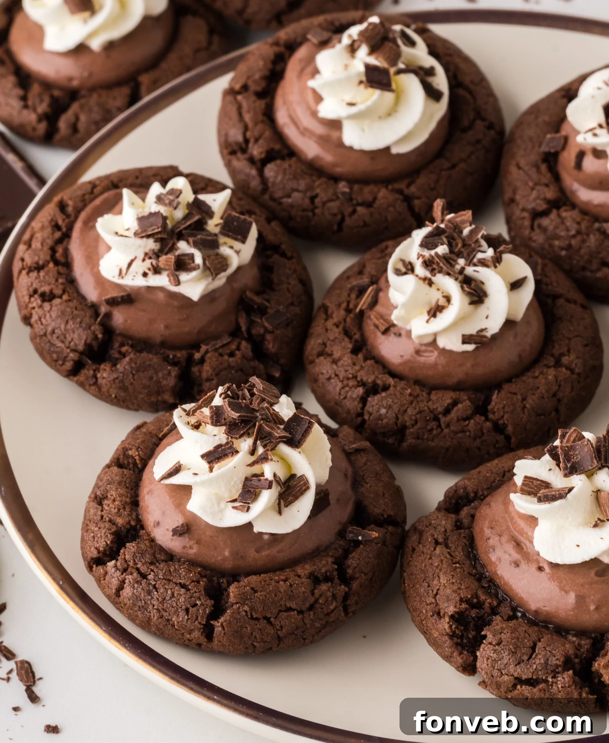 An incredibly close-up shot of Chocolate Pie Cookies on a pristine white plate, beautifully topped with a generous swirl of whipped cream and delicate chocolate shavings, inviting a taste.