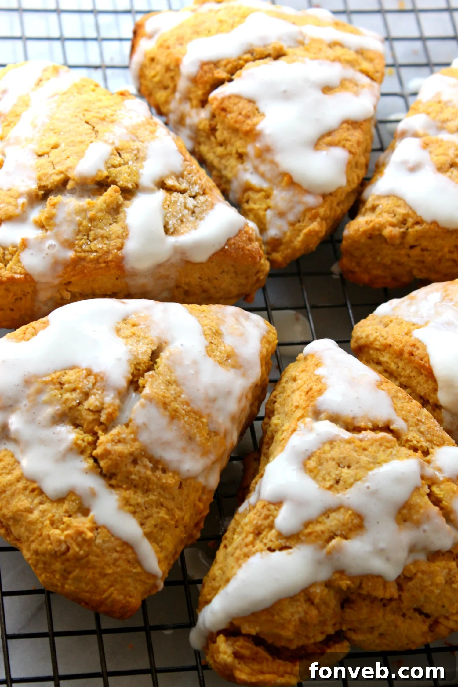 A close-up of a stack of moist pumpkin scones, showcasing their tender texture before glazing.
