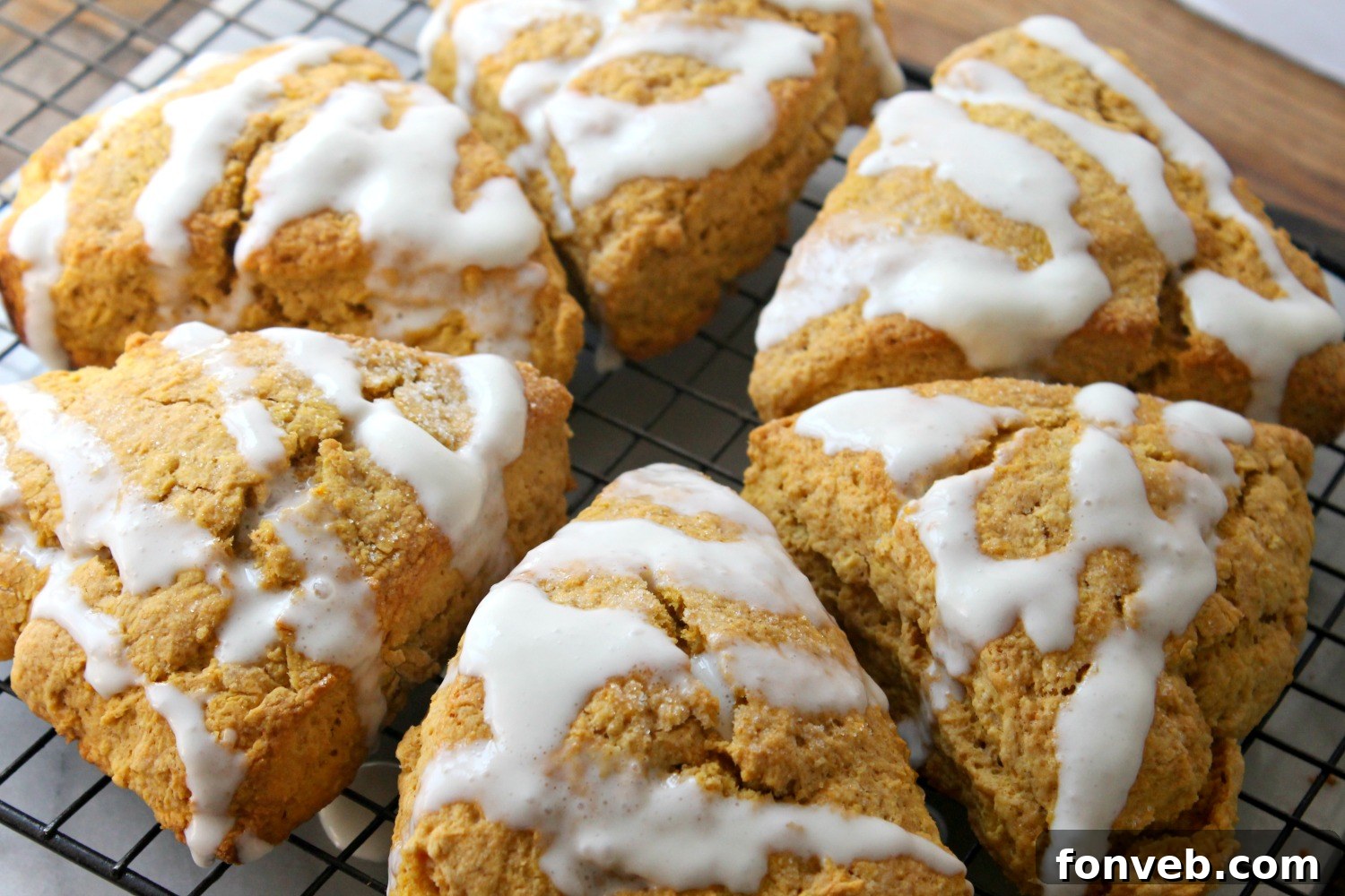 Pumpkin pie glazed scones with a rich, glossy glaze, indicating a double layer of sweetness.
