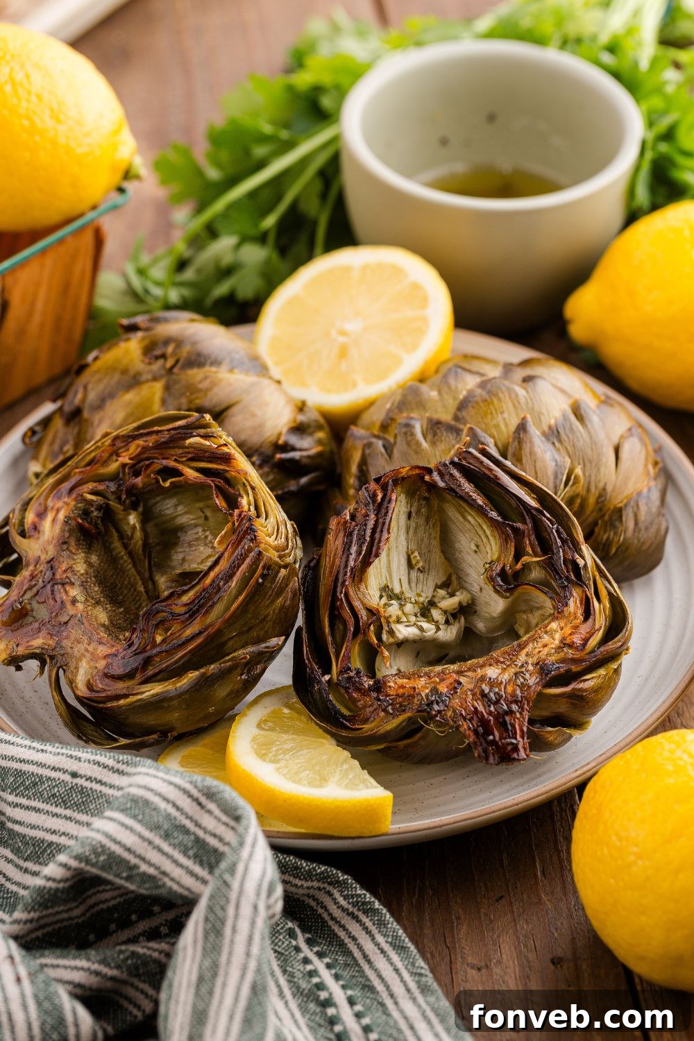 plate with artichokes and lemon wedges around the table
