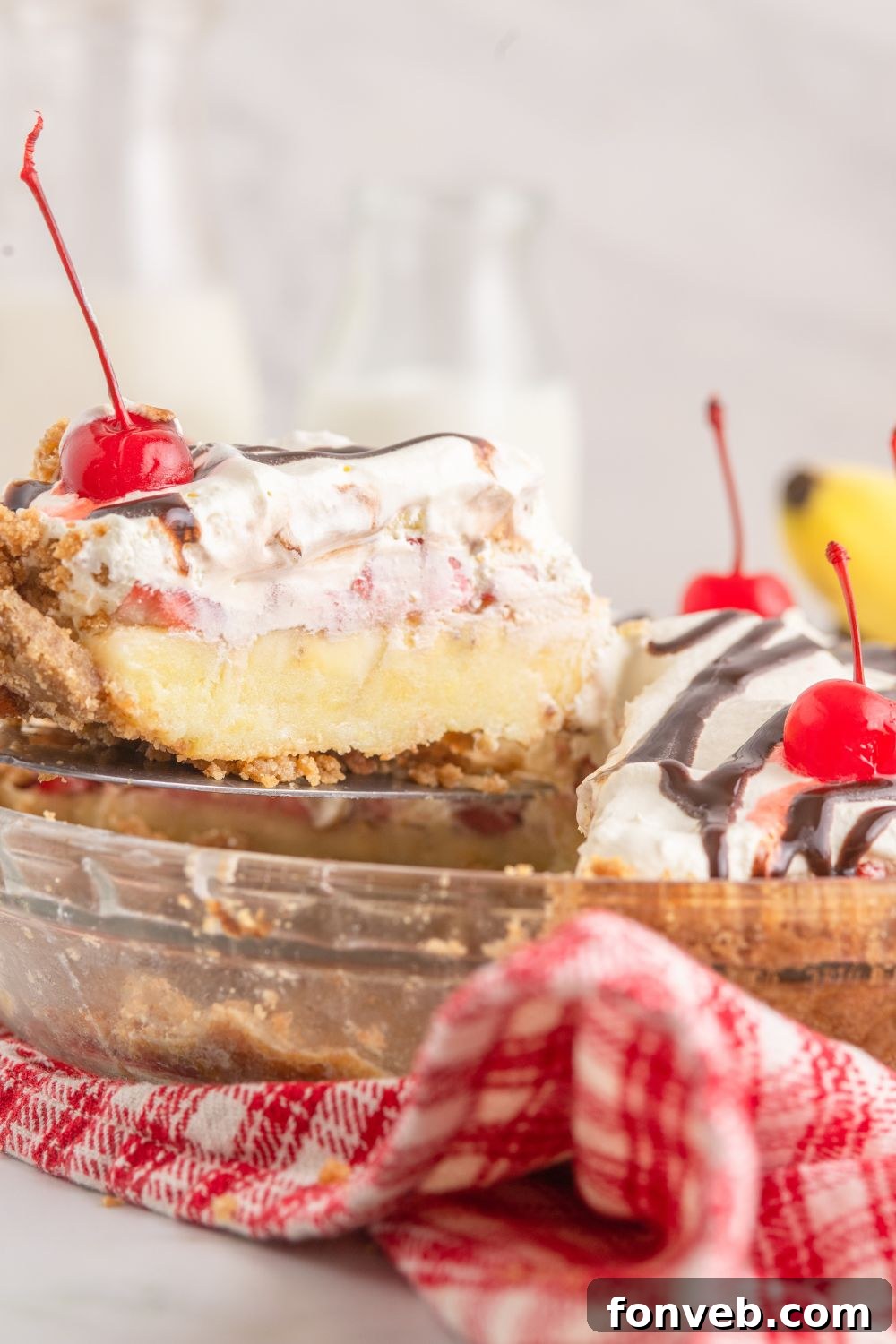 A tantalizing slice of banana split pie being carefully lifted out of the pie pan, showcasing its perfect form.