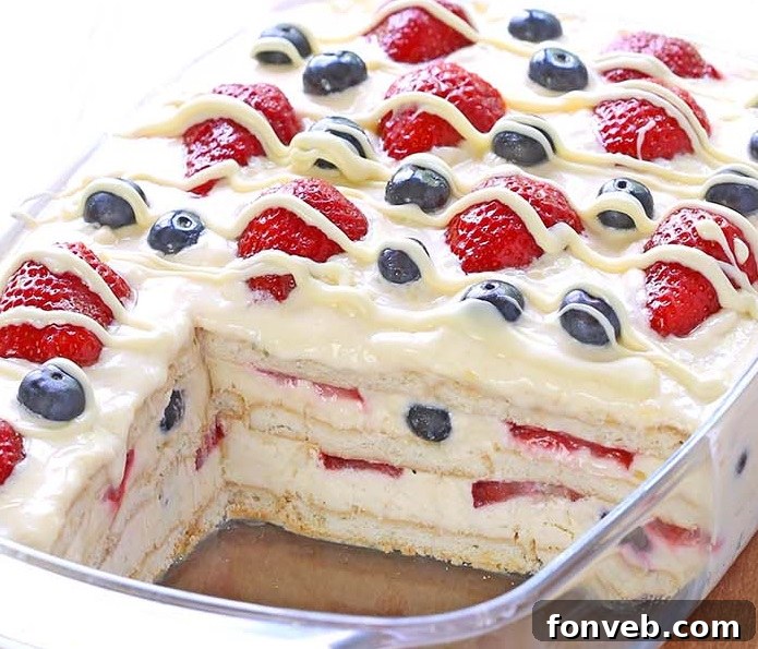 No-Bake Summer Berry Ice Box Cake with layers of cream, cookies, and colorful fresh berries