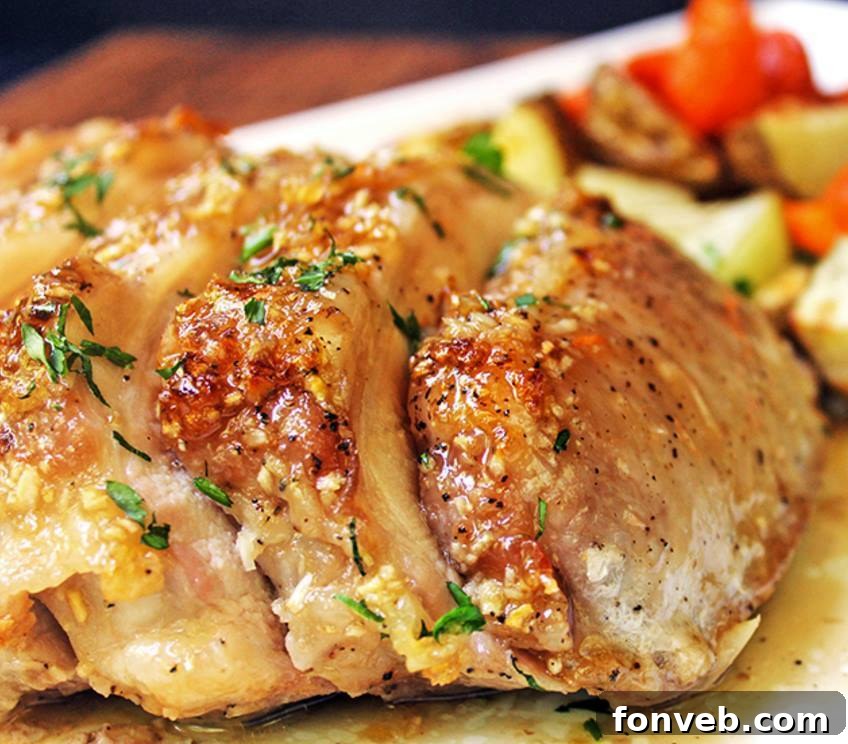 Brown Sugar Garlic Pork served with roasted carrots and potatoes on a baking sheet