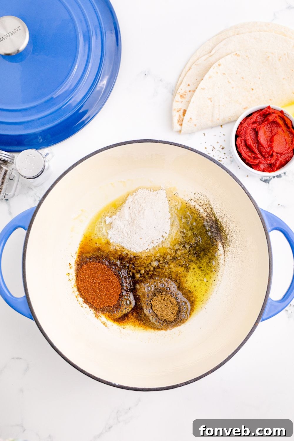 spices and oil in a pot on table for making Homemade Enchilada Sauce
