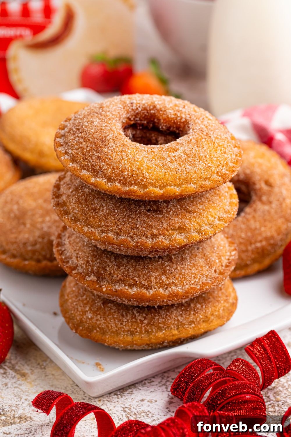Fried Strawberry Uncrustables stacked on plate with more spread out behind it on tray  