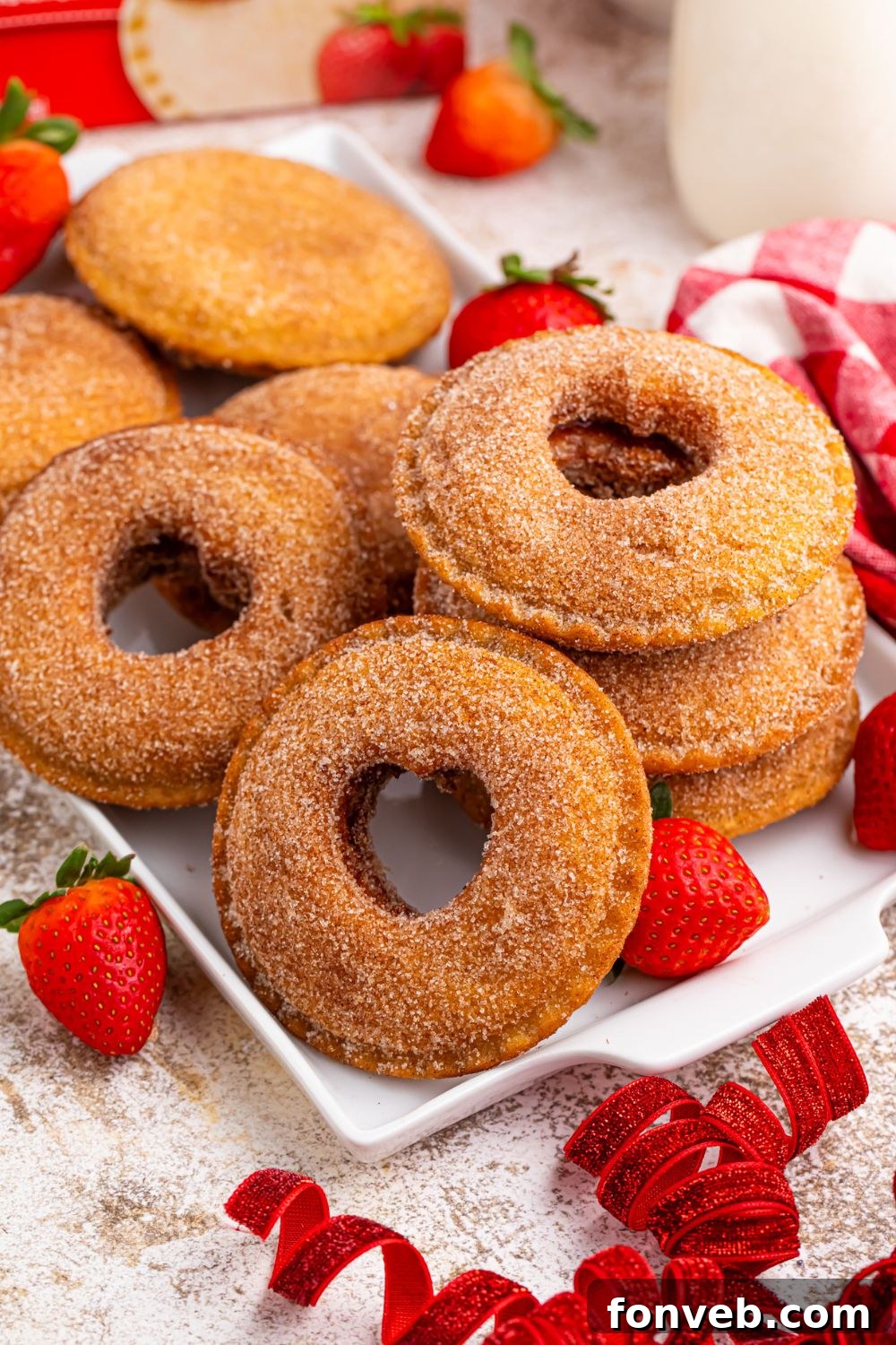 Fried Strawberry Uncrustables on table with ribbon and strawberries scattered around on table 