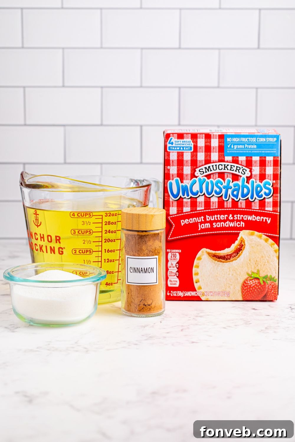 ingredients to make Homemade Strawberry Uncrustables that are fried and coated on table 