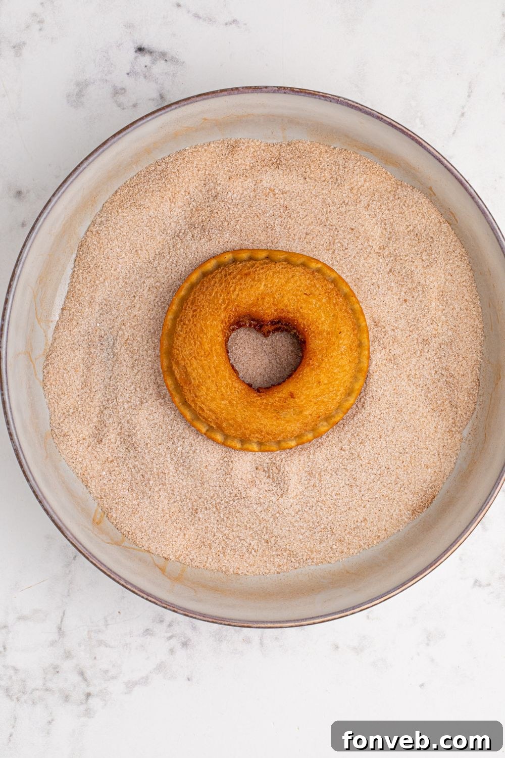 Homemade Strawberry Uncrustable fried and dipped in a cinnamon sugar bowl to coat it