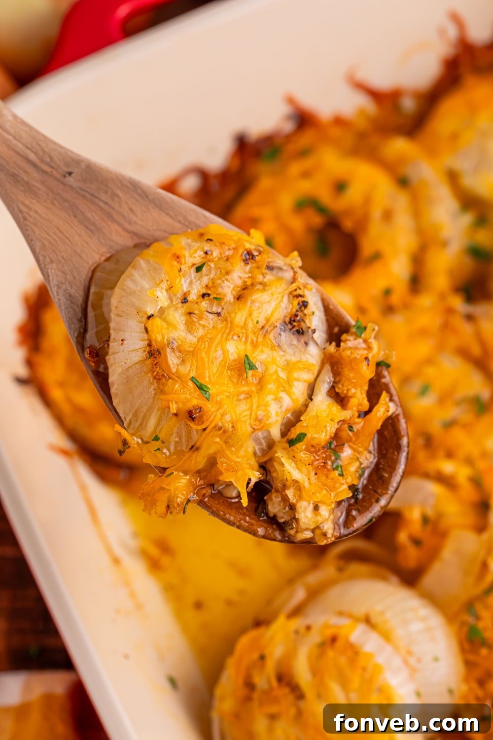 wooden spoon with baked cheesy onions on it