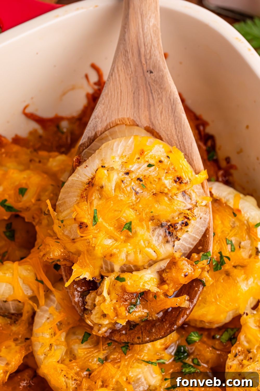 Baked Tennessee onions in a casserole pan with a spoon lifting some out