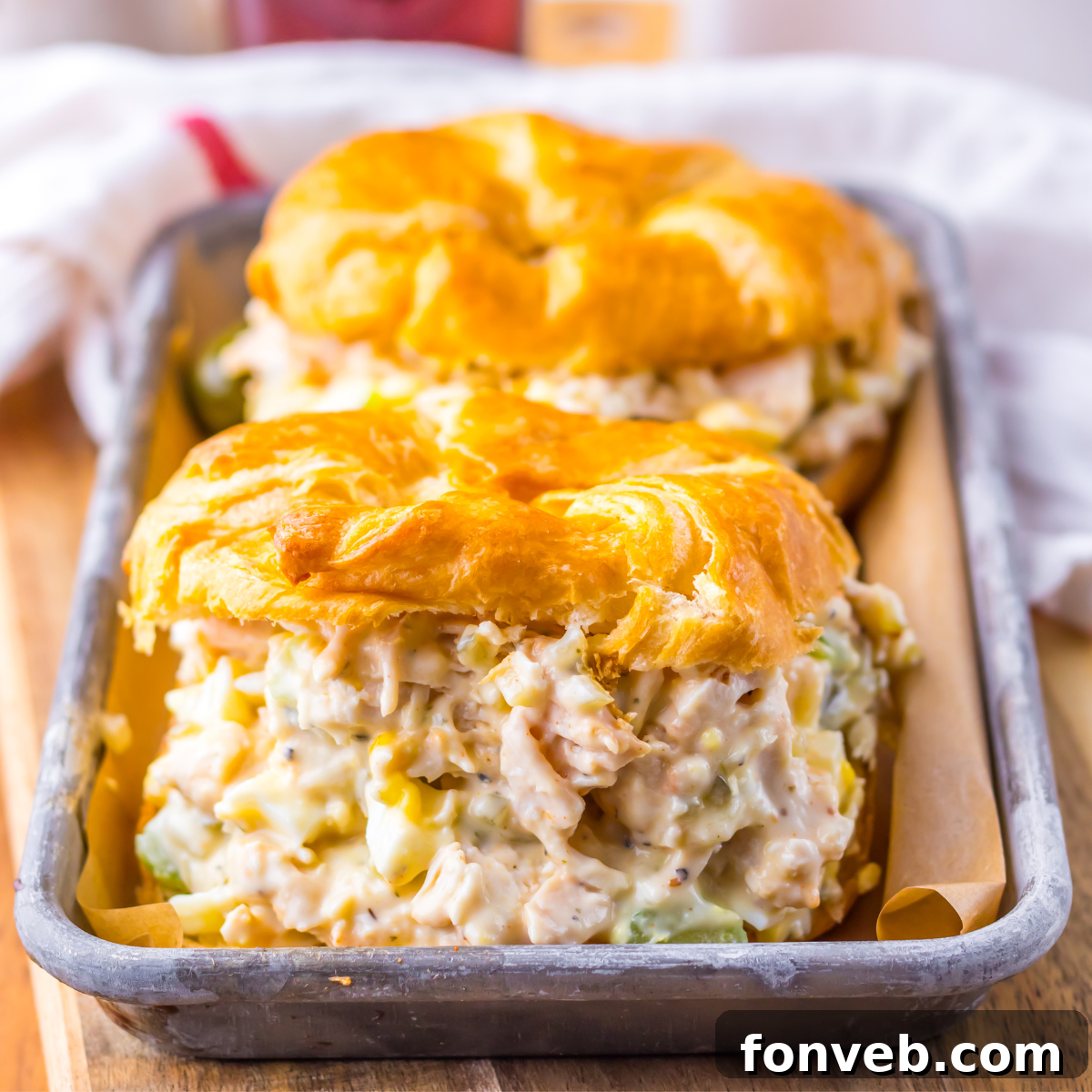 Side view of two chicken salad sandwiches on a tin tray.  