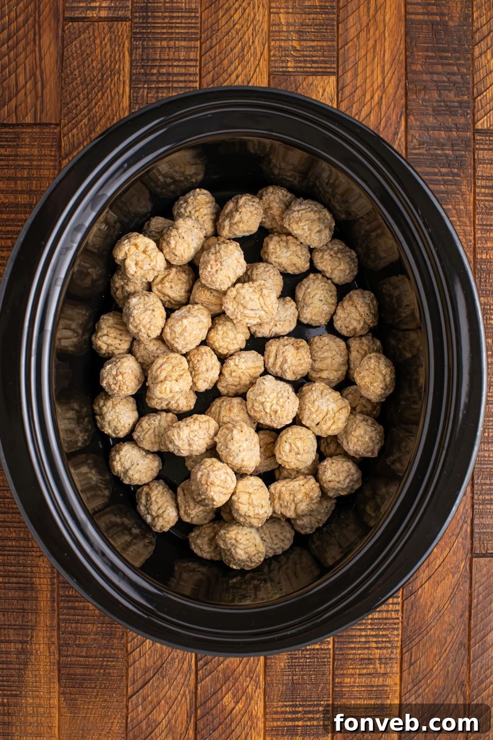 frozen meatballs in a CrockPot on table