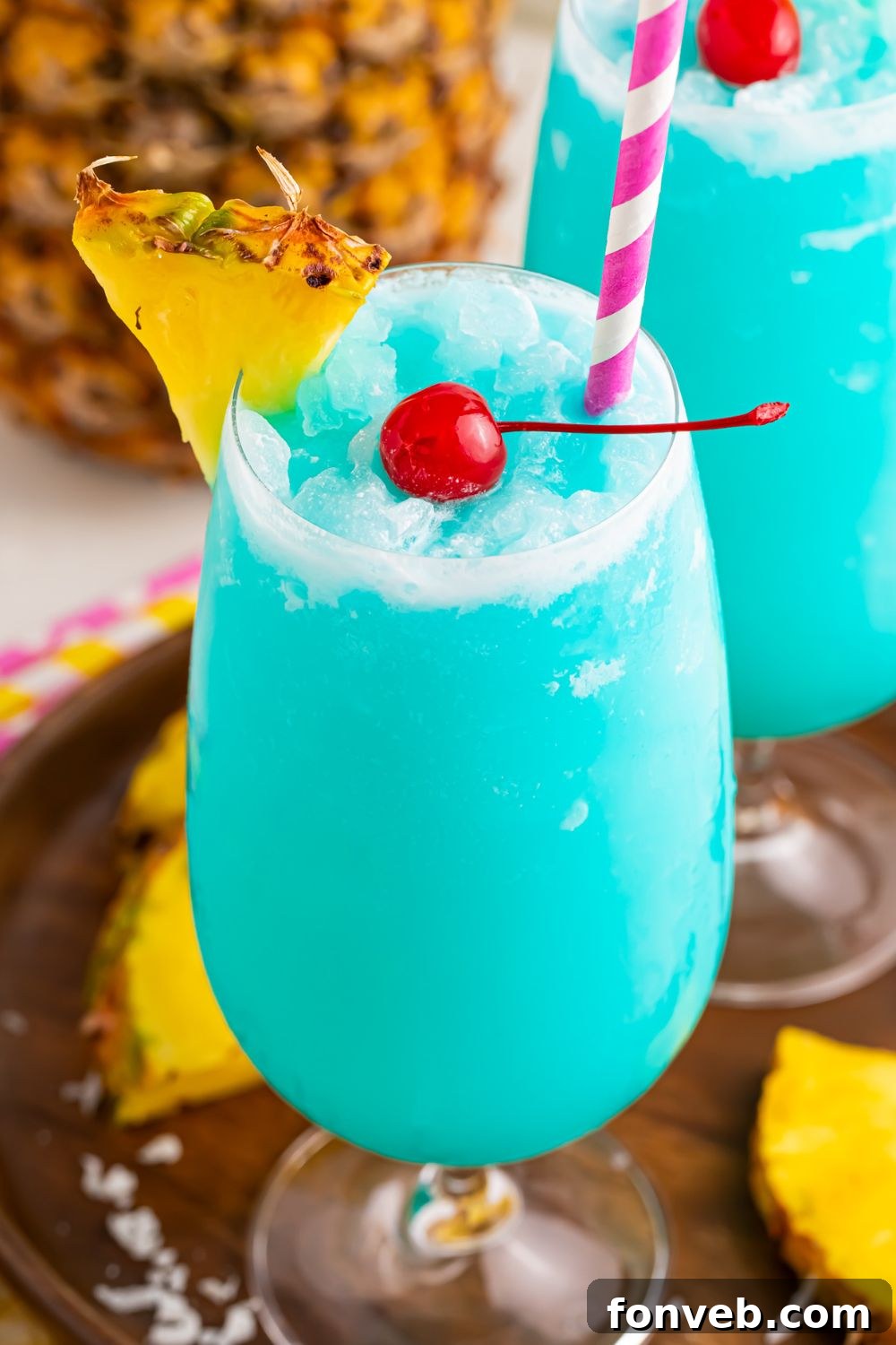 Frozen Blue Hawaiian Cocktails in glasses with pineapple slices 