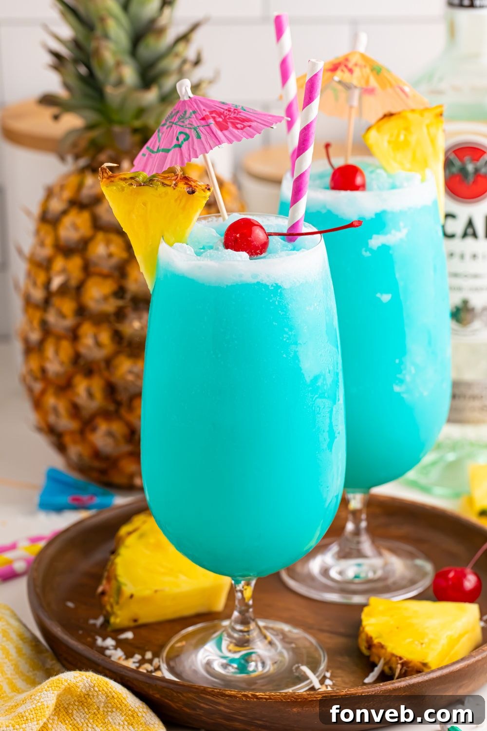 Fruity tropical rum cocktails on table with some pineapple wedges and cherries sitting on serving tray