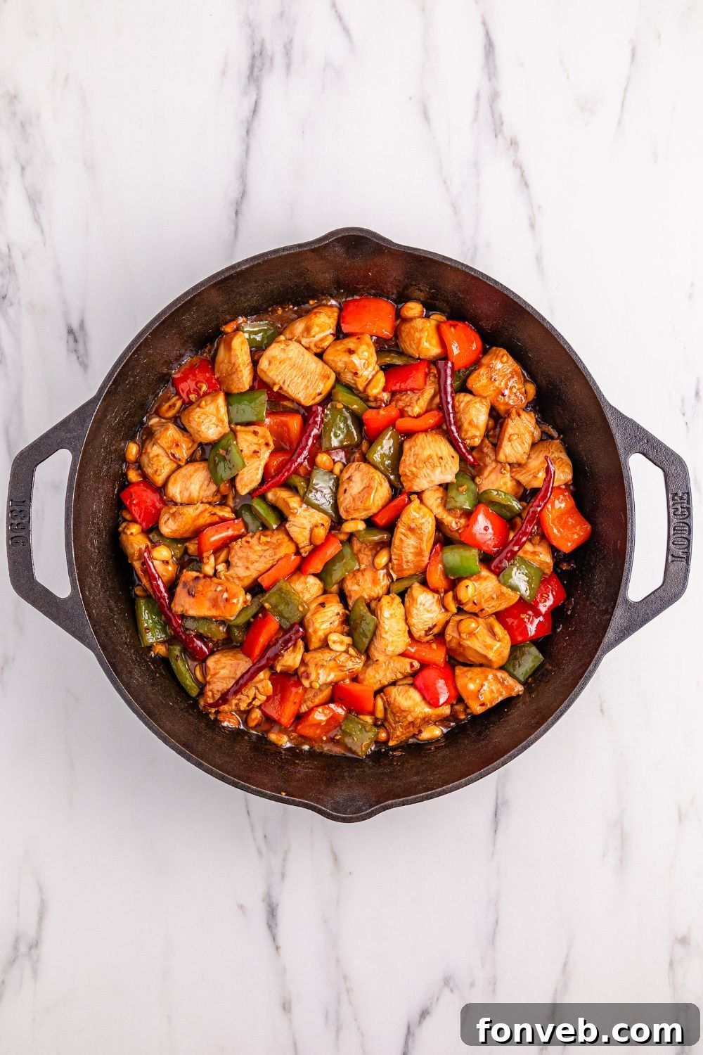 The finished Better Than Takeout Kung Pao Chicken, glistening with sauce and vibrant ingredients, served hot in a cast iron skillet.